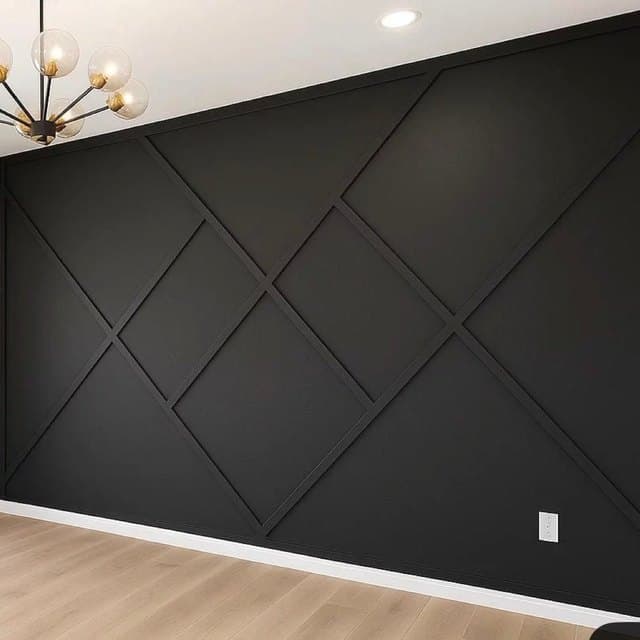 Charcoal board and batten feature wall with a brass chandelier above a pale timber floor